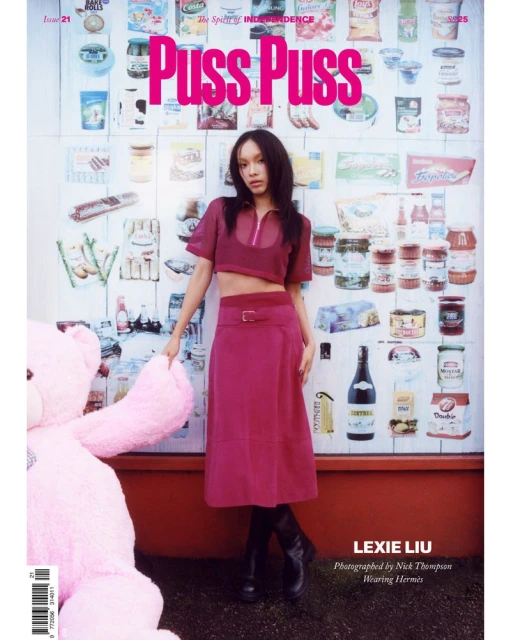 Lexie Liu poses in a magazine cover against a wall of food products, wearing a magenta top, skirt, and black boots, with a pink teddy bear.