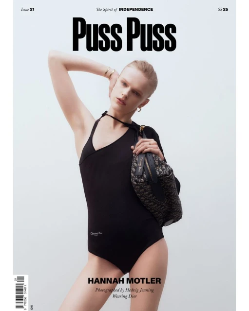 Fashion magazine cover featuring a young adult woman in a black bodysuit, holding a patterned purse, posing in front of a neutral background.