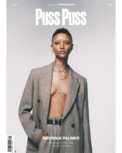 Magazine cover featuring a short-haired model in a grey suit and silver jewelry. The title "Puss Puss" is visible at the top.