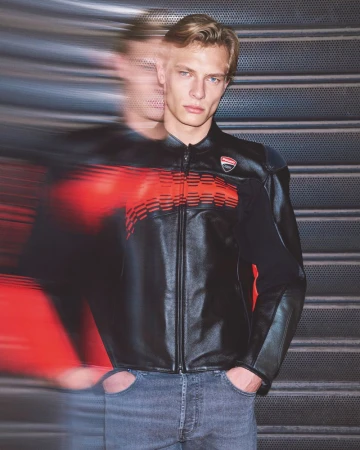 Male model wearing a black leather jacket with red stripes and jeans. A blurred, motion-effected duplicate is next to him.