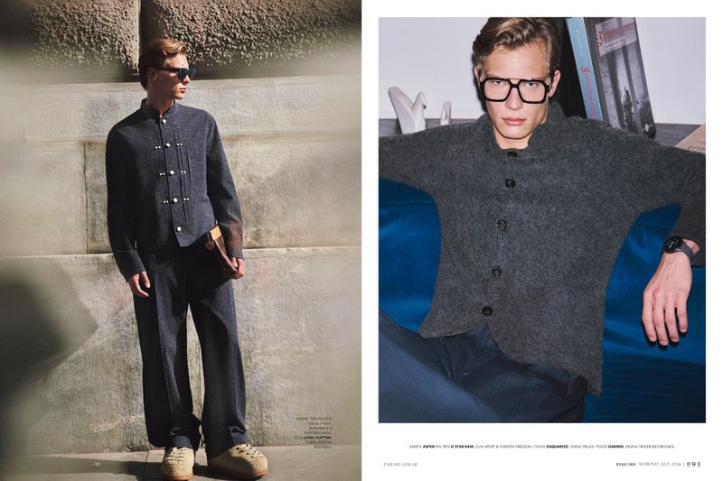 Editorial fashion shot featuring a stylish man in a gray suit with unique button details, posing against a textured stone wall in daytime.