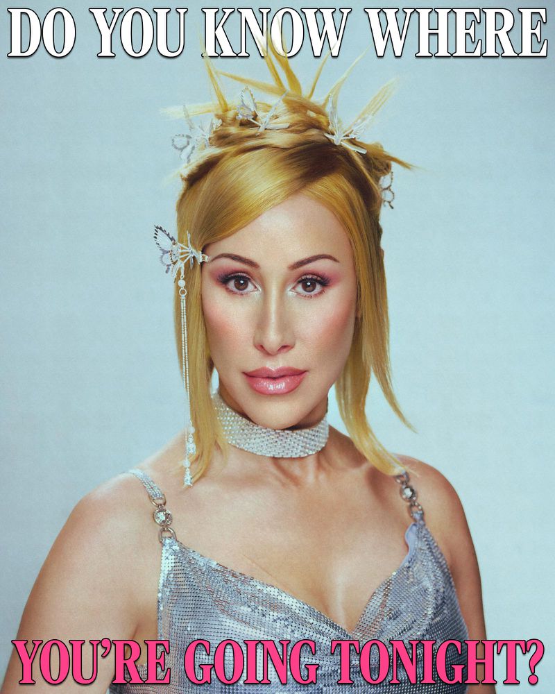 Close-up portrait of an adult female with blonde hair styled with hair accessories and wearing a silver sequin top and choker necklace.