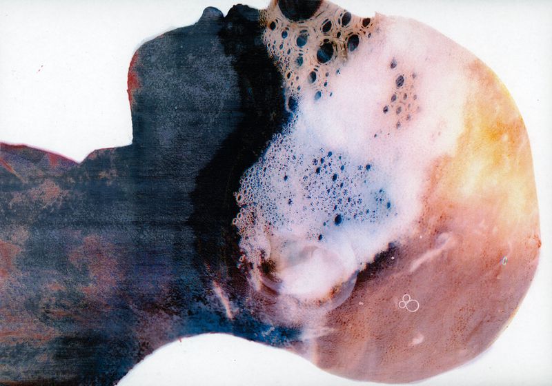 Abstract art featuring a person's silhouette with bubble-like patterns, rendered in dark blues, whites, and peach tones on a white background.