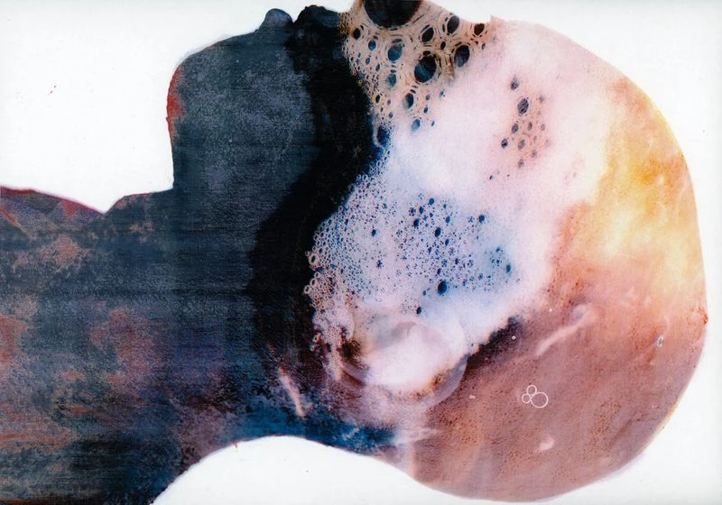 Abstract art featuring a person's silhouette with bubble-like patterns, rendered in dark blues, whites, and peach tones on a white background.