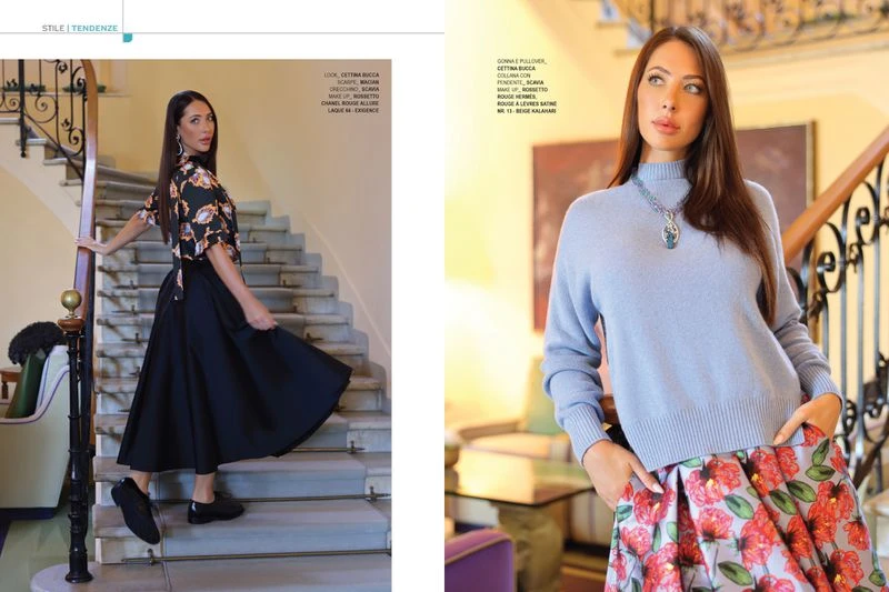 Two fashionably dressed adult women pose indoors on a staircase, modeling coordinated tops and skirts for a clothing editorial.