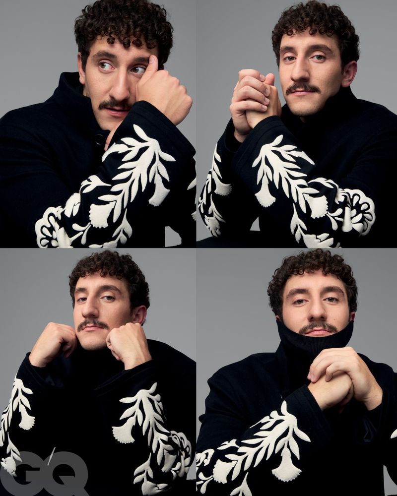 Portrait of a man with a mustache in four different poses, wearing a black turtleneck sweater with white floral embroidery.