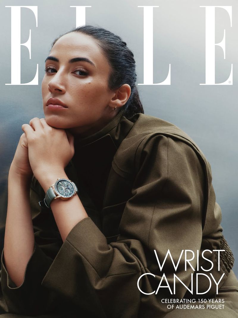 Magazine cover featuring a woman with dark hair wearing an olive jacket and a watch, with the word 'ELLE' visible.