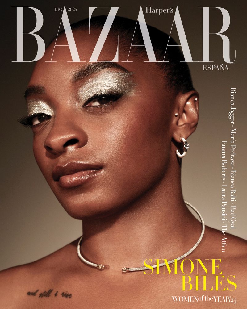 Close-up fashion magazine cover featuring Simone Biles with dramatic silver eyeshadow and a jeweled choker on a tan background.