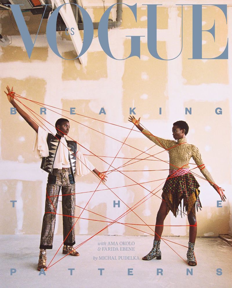 Vogue cover with two African women models in patterned outfits connected by red string against a neutral wall, featuring bold magazine text.