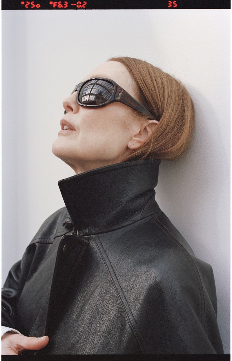 Julianne Moore wearing dark sunglasses and a black leather jacket leaning against a plain wall for Neptune Papers Issue 8.