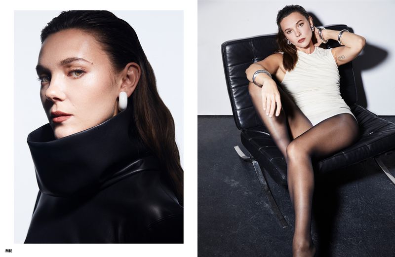Synnøve Karlsen in a high-collared black leather top and a white bodysuit seated on a black leather chair for Pibe Magazine