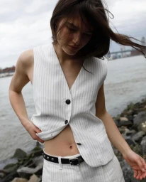 Model wearing a white pinstripe vest and trousers outdoors by a river for Rag & Bone FW2024 campaign