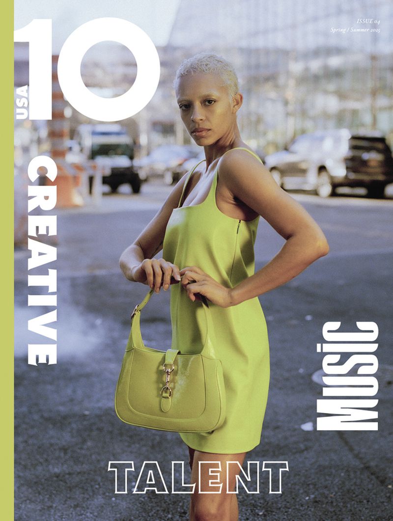 Magazine cover featuring a young woman in a green dress holding a matching purse, standing in a street with cars and buildings.