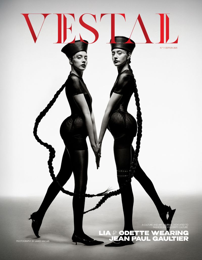 Magazine cover featuring two women in matching black outfits with long braids, posing hand-in-hand against a gradient white background.