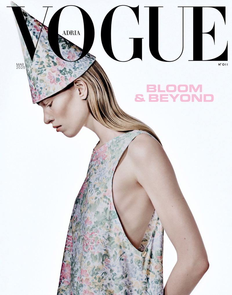 Vogue magazine cover featuring a fair-skinned woman with blonde hair, wearing a floral dress and a matching conical floral hat.
