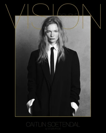 Black and white portrait of Caitlin Soetendal in a suit and tie for Vision Double Couple magazine cover, framed by gold text and lines.