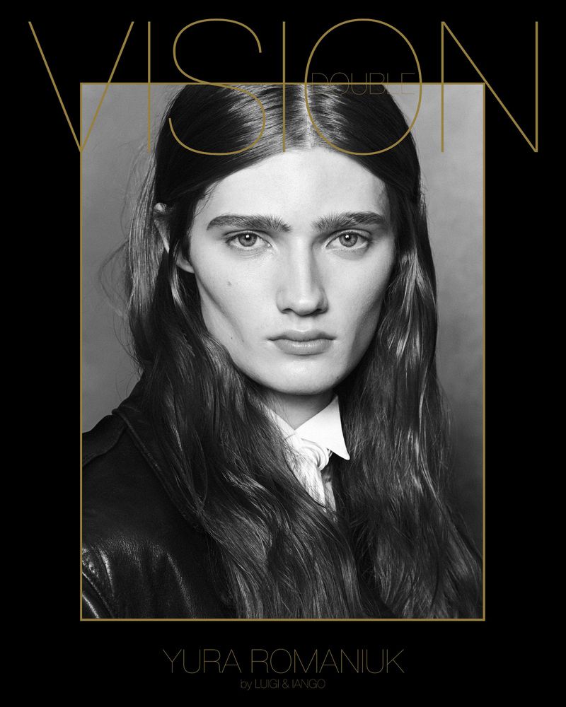 Black and white portrait of Yura Romaniuk in a square frame wearing a white shirt and black leather jacket with dark hair.