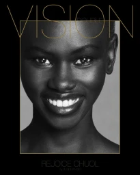 Close-up portrait of a smiling Black model with a shaved head framed against a neutral background for Double Vision magazine