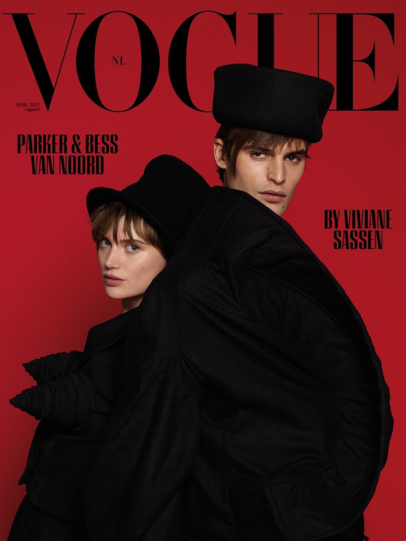 Vogue Netherlands cover featuring two models in black hats and coats against a solid red backdrop, shot by Viviane Sassen.