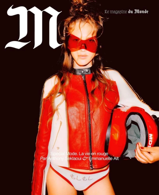 Fashion magazine cover featuring a young woman in a red racing jacket and matching eyewear holding a red helmet against a dark backdrop.