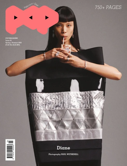 Magazine cover featuring an Asian model with straight black hair drinking from a carton with a straw against a gray background.