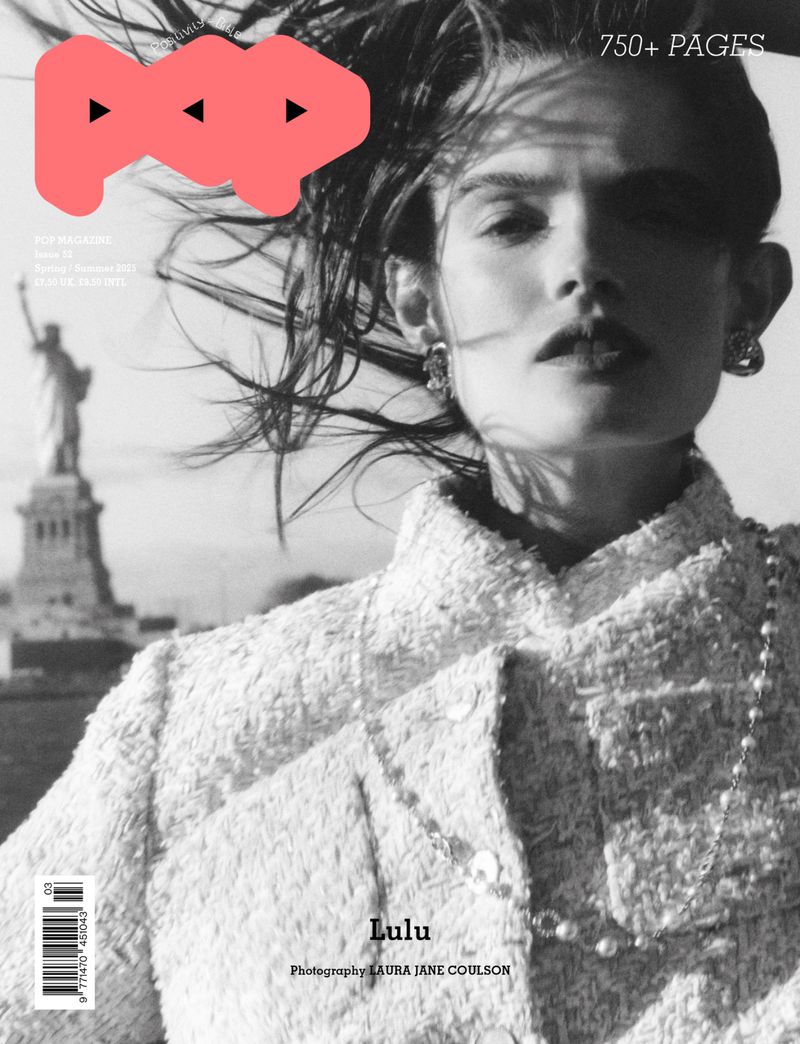 Black and white magazine cover featuring a portrait of a woman in a tweed jacket, with the Statue of Liberty visible in the background.