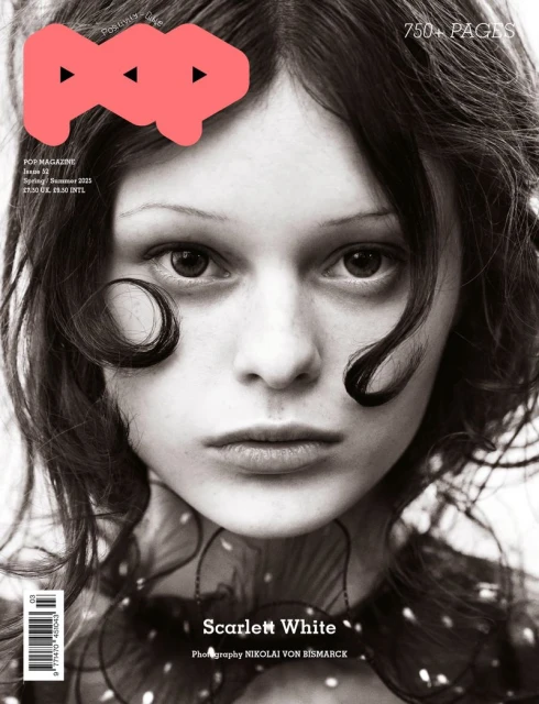 Monochrome portrait of a young adult female with dark wavy hair and a serious expression, featured on a magazine cover with distinctive text.