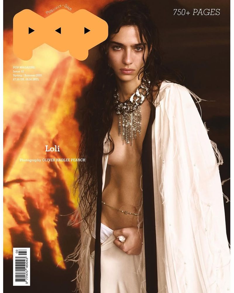 Model Loli Bahia wearing a white feathered cape and chunky silver necklace for Pop Magazine Spring/Summer 2025.