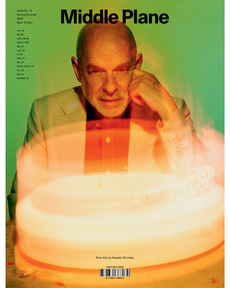 Magazine cover featuring a portrait of Brian Eno in a light yellow suit, with visible text and an orange-lit object at the bottom.