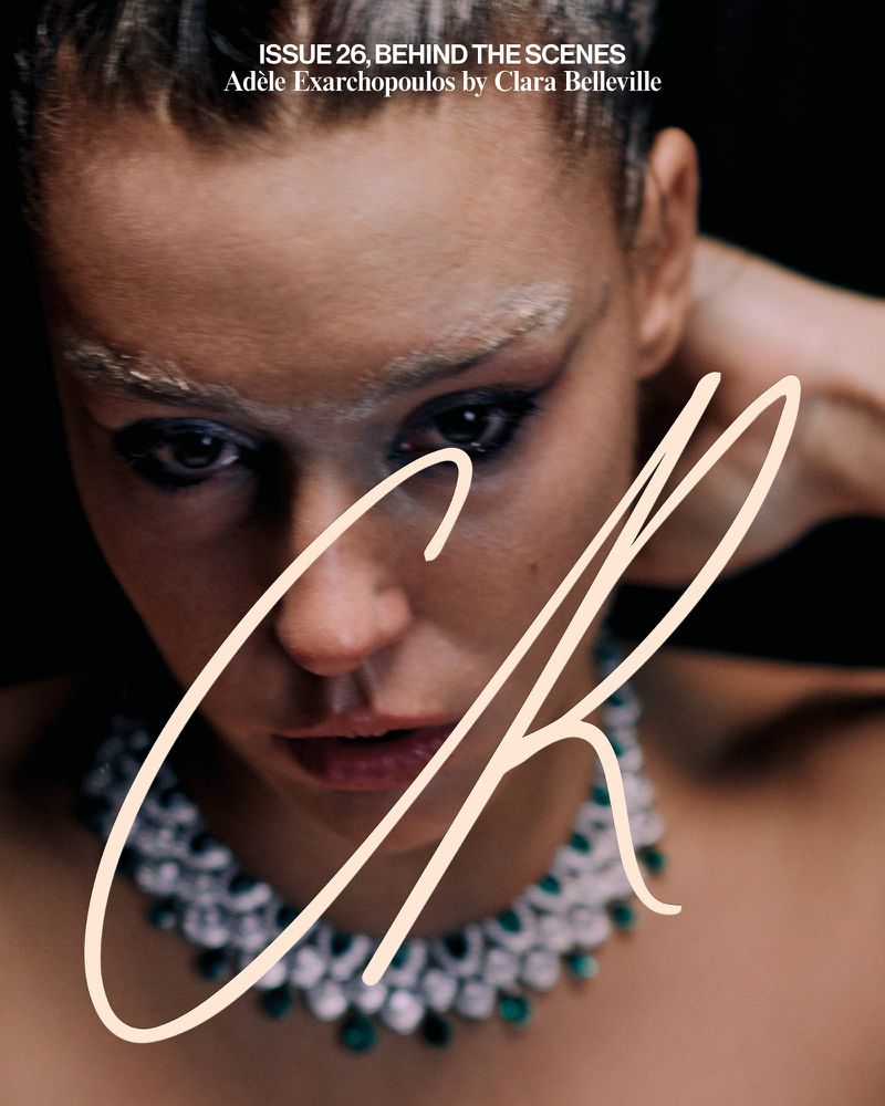 Close-up portrait of Adèle Exarchopoulos wearing an emerald necklace against a dark background for CR Fashion Book.