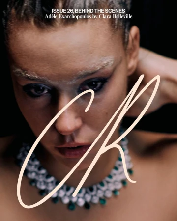 Close-up portrait of Adèle Exarchopoulos wearing an emerald necklace against a dark background for CR Fashion Book.