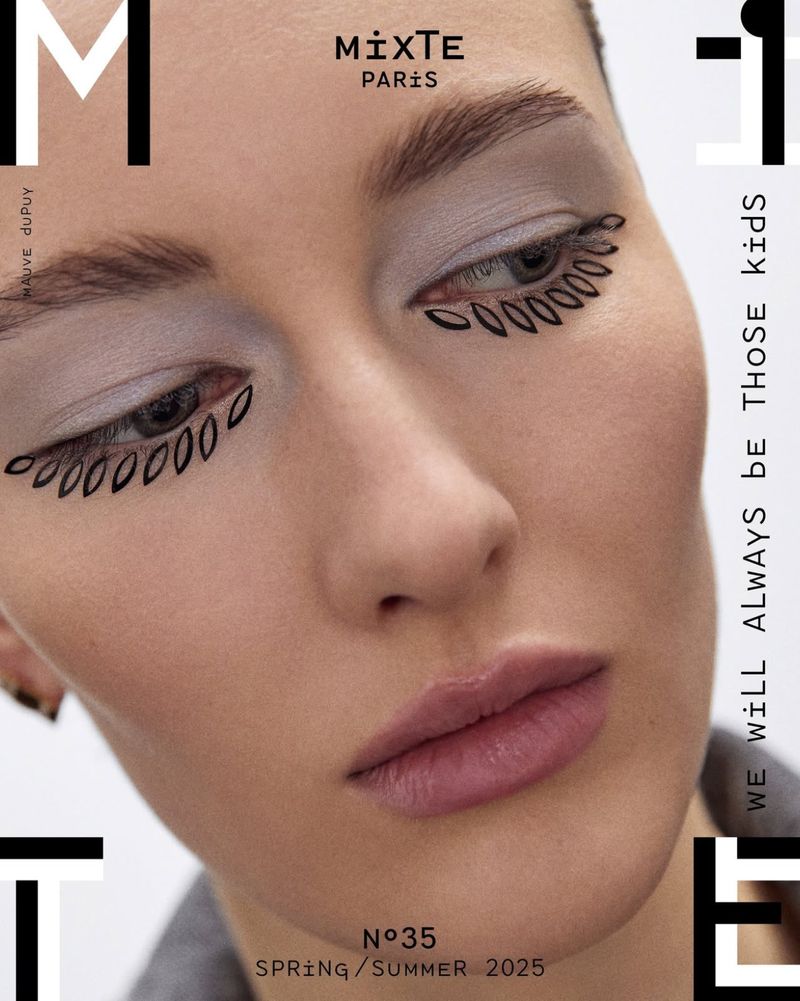 Fashion portrait of a woman with creative makeup featuring decorative leaf-like eyeliner, soft lighting, and magazine cover text overlay.
