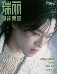 Close up portrait of an Asian man with dark hair wearing a cream knit sweater against a white textured background.