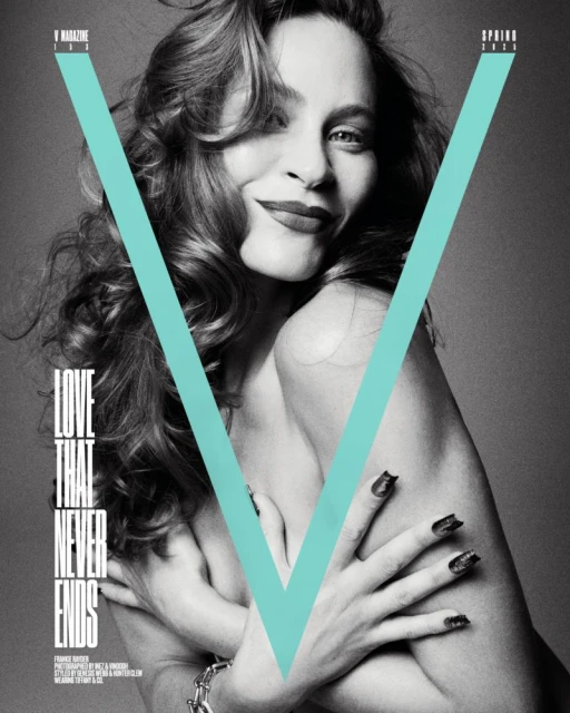 Black-and-white fashion shot of a woman with long wavy hair, posing with her arms crossed on the cover of 'V Magazine'.