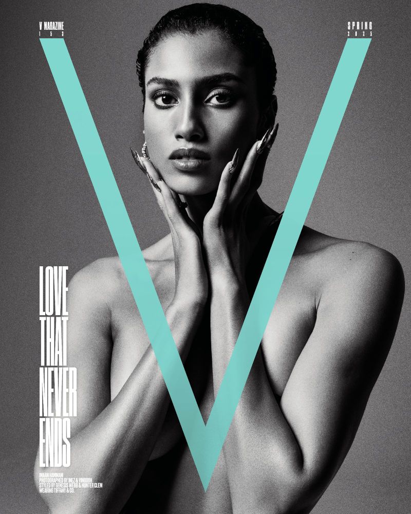 Black and white magazine cover shot of a bare-shouldered woman with hands near her face. The 'V' Magazine logo is overlaid in cyan.