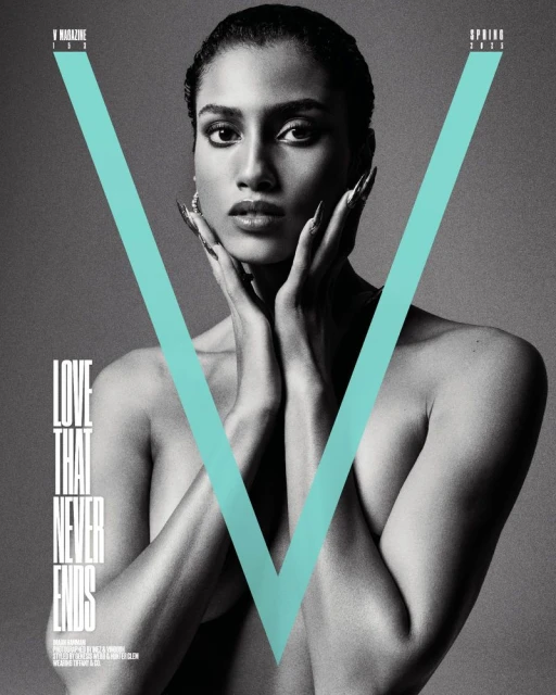 Black and white magazine cover shot of a bare-shouldered woman with hands near her face. The 'V' Magazine logo is overlaid in cyan.