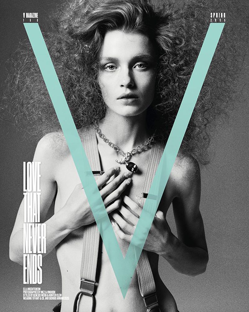 Black and white fashion magazine cover featuring a woman with curly hair, a necklace, and suspenders, against a light blue V graphic.