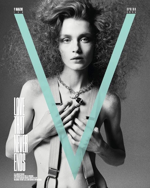 Black and white fashion magazine cover featuring a woman with curly hair, a necklace, and suspenders, against a light blue V graphic.