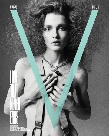 Black and white fashion magazine cover featuring a woman with curly hair, a necklace, and suspenders, against a light blue V graphic.