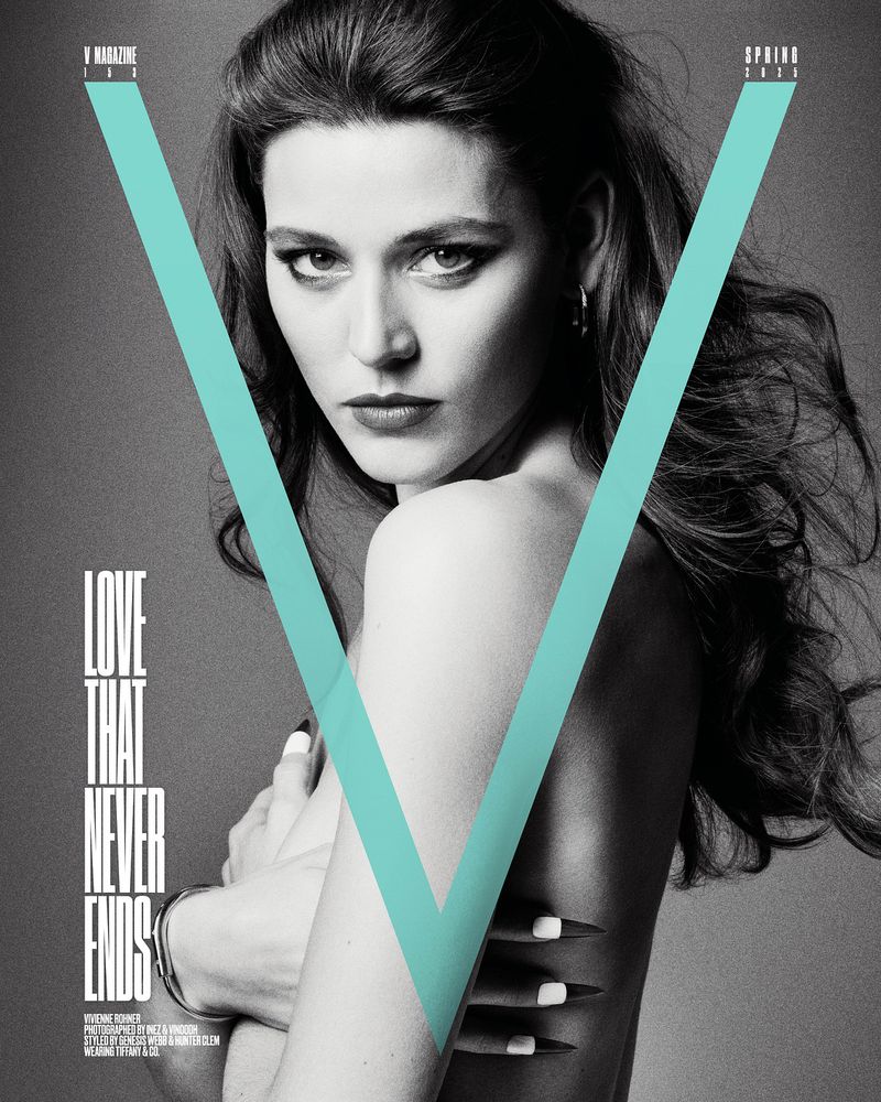 Black and white portrait of a young woman with her arms crossed against a light blue 'V', magazine cover, fashion editorial photography.