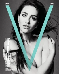 Black and white magazine cover portrait of a woman with dark hair in a braid, featuring a large cyan V graphic overlay.