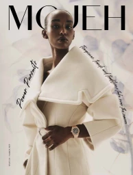 Model in a cream structured coat wearing a metallic watch against a soft botanical background for Mojeh Magazine March 2025 Cover