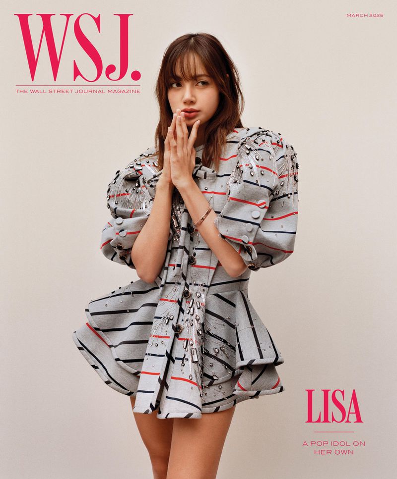 Lisa from Blackpink poses on the cover of WSJ. Magazine March 2023 issue wearing a short striped dress with puffed sleeves.