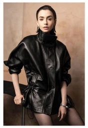 Lily Collins seated in an oversized black leather jacket with slicked-back hair against a warm textured backdrop.
