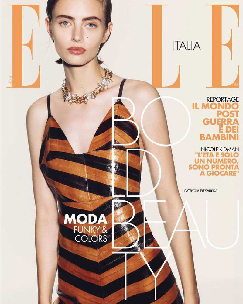 Elle Italia magazine cover featuring a woman with a tan and black striped dress and a gold necklace, with bold text overlaying the image.