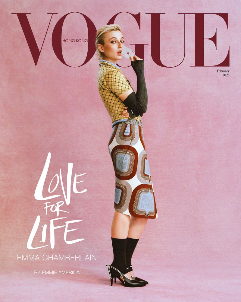 Vogue Hong Kong cover featuring Emma Chamberlain in patterned top, skirt, socks, and heels on a pink background, holding a playing card.