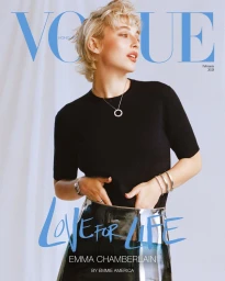 Emma Chamberlain wearing a black t-shirt and metallic skirt against white fabric