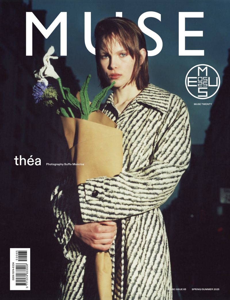 Muse Magazine cover featuring a woman in a striped coat, holding a paper bag with flowers, against a muted urban background with text.