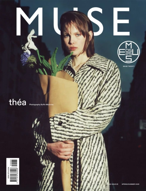 Muse Magazine cover featuring a woman in a striped coat, holding a paper bag with flowers, against a muted urban background with text.