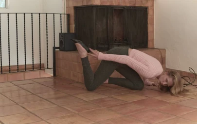 Model Abby Champion posing on a tiled floor wearing a pink sweater and dark leggings for CAP 74024 editorial.